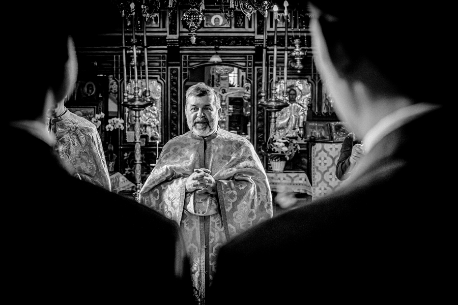 Preot oficiind ceremonia religioasă de nuntă într-o biserică din București, surprinsă de fotograf nuntă București – AdPhoto