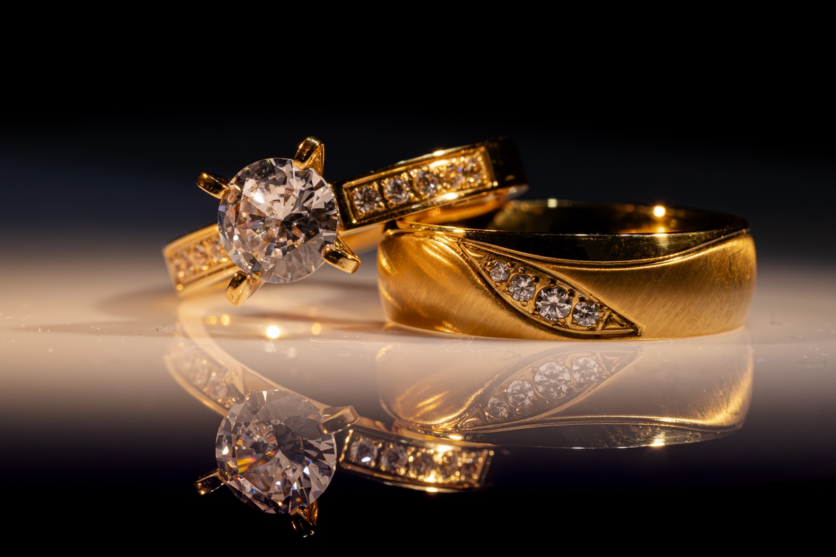 Fotograf nuntă București – verighete și inel de logodnă fotografiate artistic, cu reflexie elegantă, de AdPhoto