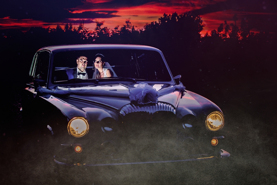 Fotograf nuntă București – mire și mireasă într-o mașină clasică la apus – fotografie artistică realizată de AdPhoto