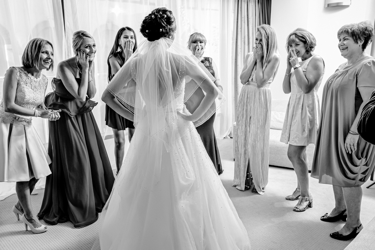 Pregătiri de nuntă – mireasa surprinsă în momentul emoționant al reacției domnișoarelor de onoare, fotografie realizată de AdPhoto București