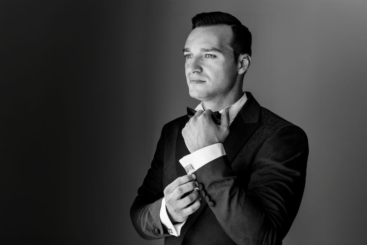 Portret alb-negru cu mirele la pregătiri, surprins într-un moment de concentrare înainte de nuntă, fotograf profesionist de nuntă București