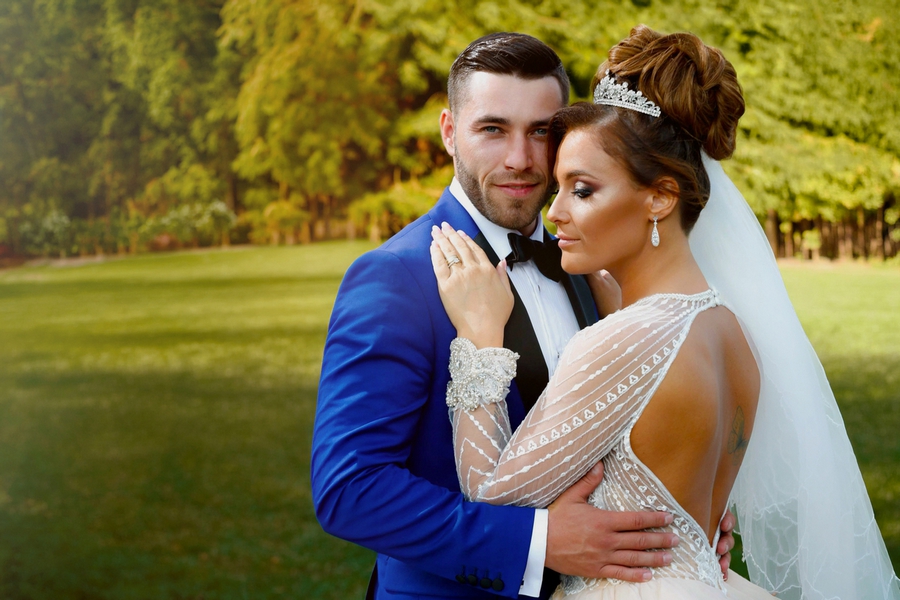 Mireasa în rochie albă cu dantelă și mirele în costum albastru– AdPhoto